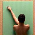 Eine Person liegt entspannt auf einer Yogamatte, die Gliedmaßen sind leicht und die Körperhaltung ist gelöst, was auf eine tiefe Entspannung hinweist.